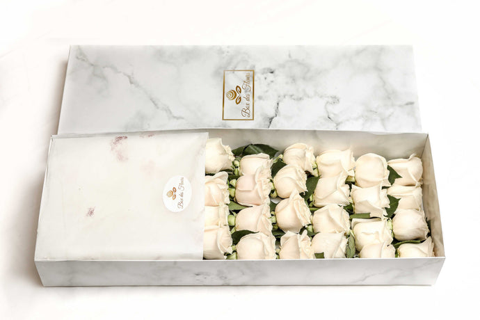 A close-up image of 24 white roses from Vancouver's Box Des Fleurs in a Luxury Marble Box. The elegant white marble complements the roses' natural beauty. Perfect for a sophisticated and romantic gift or decoration. Order now for fresh, handcrafted flowers from Vancouver's premier florist.