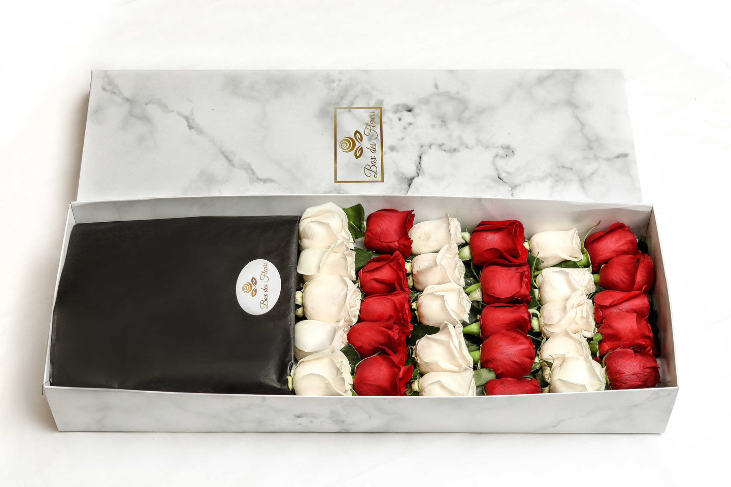 A close-up of 30 roses in a luxury marble box by Vancouver's Box des Fleeurs. The arrangement has an alternating color combination of red and white roses.