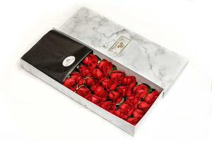 A close-up image of 24 red roses from Vancouver's Box Des Fleurs in a Luxury Marble Box. The elegant white marble complements the roses' natural beauty. Perfect for a sophisticated and romantic gift or decoration. Order now for fresh, handcrafted flowers from Vancouver's premier florist.