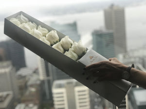 A close-up view of a dozen stunning white roses arranged by Vancouver's Box Des Fleurs. Each rose features delicately curled petals that showcase their natural beauty. This elegant bouquet makes the perfect gift to add sophistication and romance to any space. Order now for fresh, handcrafted flowers from Vancouver's premier florist.