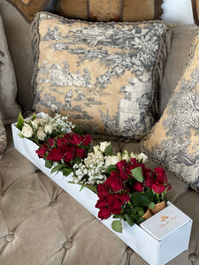 A close-up of an arrangement of white and red roses with baby's breaths and greenery in a marble box from Vancouver's Box des Fleurs. This arrangement fits the flowers in ice-cream cones, crating a very unique arrangement. 