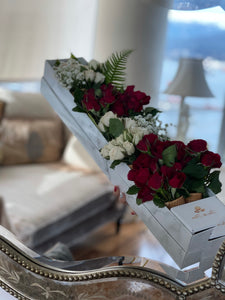 A close-up of an arrangement of white and red roses with baby's breaths and greenery in a marble box from Vancouver's Box des Fleurs. This arrangement fits the flowers in ice-cream cones, crating a very unique arrangement. 