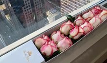 Close-up of a dozen of white rose with pink and purple accents from Vancouver's Box Des Fleurs. The petals are delicately curled, and the color gradient goes from pale pink to light purple, creating an ombre effect. An elegant gift to enhance any space. Order now for fresh, handcrafted flowers from Vancouver's premier florist.