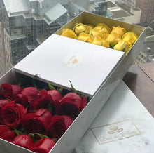 A close-up image of 24 beautiful red and yellow roses from Vancouver's Box Des Fleurs arranged in an infinity symbol shape, with stems meeting in the middle in a Luxury Marble Box. One side of the box is filled with 12 red roses and the other side has 12 yellow roses. The elegant white marble complements the roses' natural beauty, adding a touch of sophistication to any space. Order now for fresh, handcrafted flowers from Vancouver's premier florist.