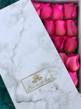 A close-up image of 24 magenta pink roses from Vancouver's Box Des Fleurs in a Luxury Marble Box. The elegant white marble complements the roses' natural beauty. Perfect for a sophisticated and romantic gift or decoration. Order now for fresh, handcrafted flowers from Vancouver's premier florist.