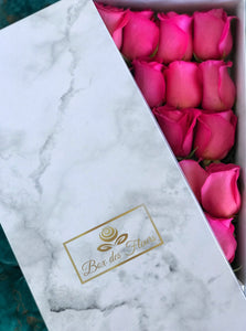 A close-up image of 24 magenta pink roses from Vancouver's Box Des Fleurs in a Luxury Marble Box. The elegant white marble complements the roses' natural beauty. Perfect for a sophisticated and romantic gift or decoration. Order now for fresh, handcrafted flowers from Vancouver's premier florist.